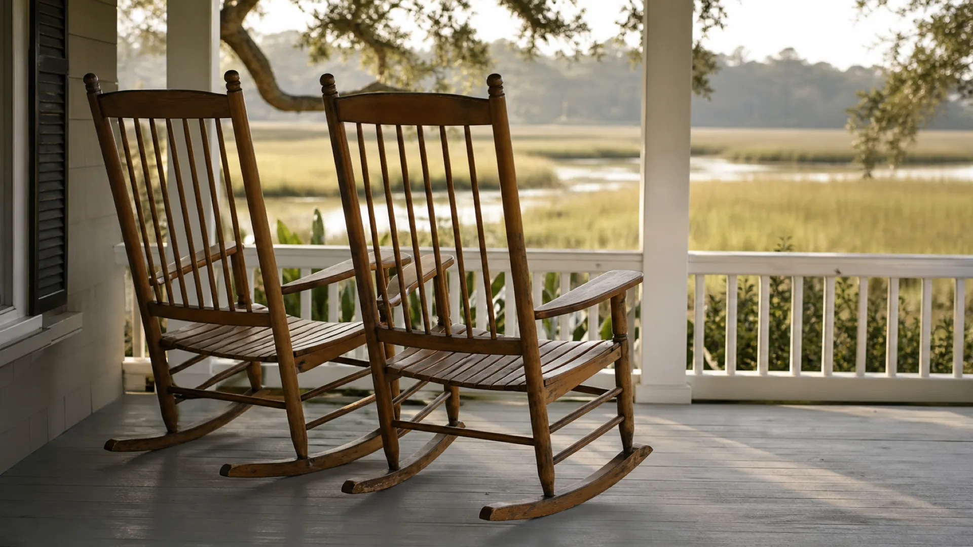 Two rocking chairs side by side on a shaded Lowcountry porch in morning light